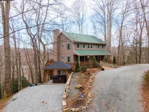 a large house with a green roof on a road at Peaceful Wood Haven at Mill Ridge in Banner Elk