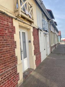 a brick building with a door on the side of it at Ma Toquade in Quiberville