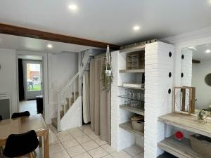 a kitchen and dining room with a white brick wall at Ma Toquade in Quiberville