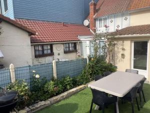 a table and chairs in the yard of a house at Ma Toquade in Quiberville