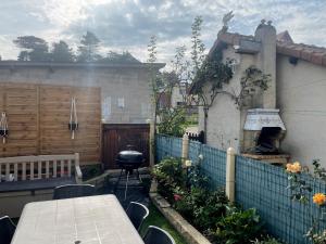 a backyard with a grill and a table and a fence at Ma Toquade in Quiberville +6 photos