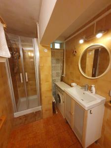 y baño con lavabo, ducha y lavadora. en Casa - La Faggeta, en Subiaco