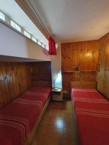 Dos camas en una habitación con paneles de madera. en Casa - La Faggeta, en Subiaco 14 fotos más