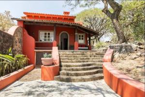 a small red house with stairs in front of it at Private 5-Bedroom Compound with Pool Tepoztlán Retreat in Tepoztlán +32 photos