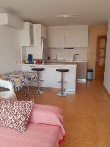 Una cocina con un sofá y una mesa en una habitación. en APARTAMENTO EL TIMON, en Carboneras