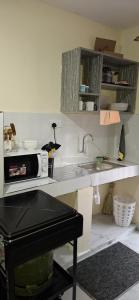 una cucina con un lavandino e un microonde su un bancone di Abbey's bnb a Kikuyu