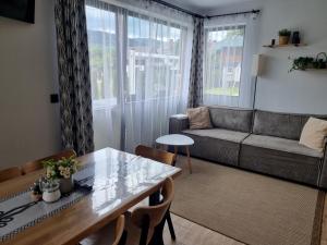 クロシチェンコにあるDomek Otulony Słońcemのテーブルとソファのあるリビングルーム