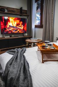 a bedroom with a bed with a fire in the fireplace at VujSki - Gondola Apartman in Brzeće