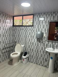 a bathroom with a toilet and a sink at Hotel Pedacito de Cielo in Boca Tapada