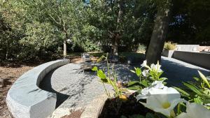 un jardin avec des fleurs blanches et un chemin de pierre dans l'établissement Château de Jouques, à Gémenos