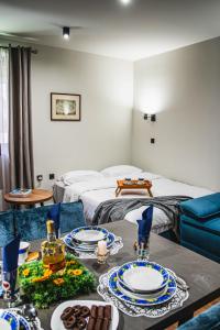 a room with a bed and a table with plates on it at VujSki - Gondola Apartman in Brzeće