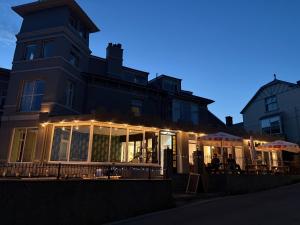a building with a restaurant in front of it at night at The Marine Hotel in Criccieth