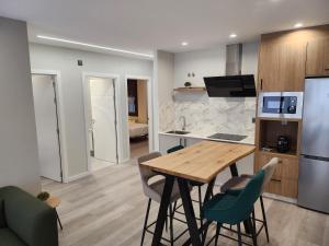 a kitchen and dining room with a wooden table and chairs at CREDENCIAL Bulevar in Sarria