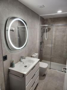 a bathroom with a sink and a toilet and a mirror at CREDENCIAL Bulevar in Sarria