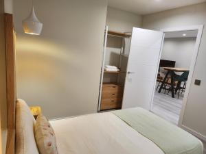 a bedroom with a bed and a door to a dining room at CREDENCIAL Bulevar in Sarria