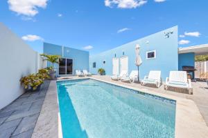 a swimming pool in a villa with blue walls at Apricity Suites Aruba in Noord