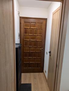 a wooden door in a room with a refrigerator at Natalia in Sauze d'Oulx +1 photo