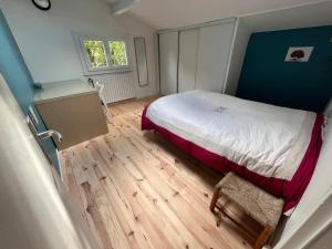 a bedroom with a bed and a wooden floor at Chambres d'hotes du Prieur in Léognan