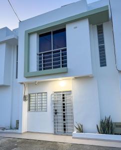 une maison blanche avec une fenêtre dans l'établissement Amalfi Home 2Hab AA, à Montería