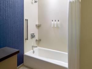 a bathroom with a white tub and a sink at Fairfield by Marriott Inn & Suites Alpharetta Avalon Area in Alpharetta +16 photos