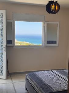 a bedroom with a window with a view of the ocean at Le Relax, Dellys  +2 photos