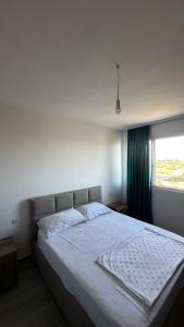 a large bed in a bedroom with a window at Apartamente me qera tale plazh lezhë in Lezhë