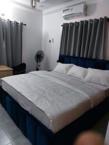 Bett mit blauem Kopfteil in einem Zimmer in der Unterkunft Apartments in Lekki in Lekki