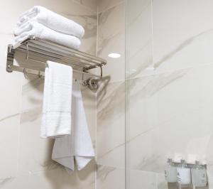 a bathroom with white towels on a towel rack at RM Campana Hotel in Campana +16 photos