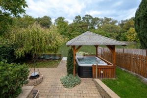 a gazebo with a hot tub in a yard at Arborétum Nyaraló Szarvas - Kültéri jakuzzival in Szarvas