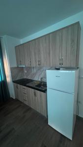 a kitchen with a white refrigerator and a sink at Apartamente me qera tale plazh lezhë in Lezhë +7 photos