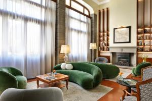 a living room with green furniture and a fireplace at Hotel Kraft in Florence