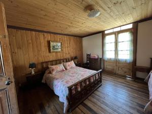a bedroom with a bed and a wooden floor at Hostal Casa Rosada, Valle del Elqui in Rivadavia