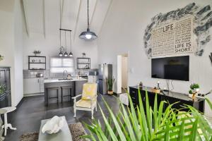 a living room with a kitchen with a tv at Peace Haven Cottage St Helena Bay in Stompneusbaai