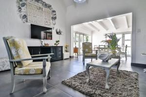 a living room with a chair and a table at Peace Haven Cottage St Helena Bay in Stompneusbaai