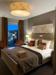 a bedroom with a large bed and a large window at Hotel Boerderij Restaurant De Gloepe in Diffelen