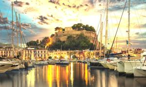 un grupo de barcos atracados en un puerto con un castillo en Casa Isabel in El Verger, en El Verger
