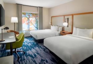 a hotel room with two beds and a desk at Fairfield by Marriott Inn & Suites Alpharetta Avalon Area in Alpharetta