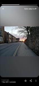 une rue vide avec un coucher de soleil au loin dans l'établissement Station Guesthouse - key pad entry with parking, à Lancaster