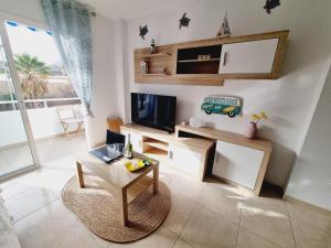 a living room with a tv and a table at Sal Marina in Puertito de Güímar