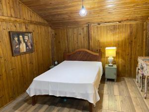 a bedroom with a bed in a wooden room at CHALÉS DO VÔ LÉRIO/TORRES-RS in Torres