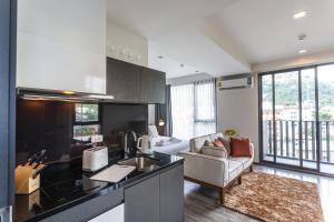 a living room with a kitchen and a bedroom at The Deck Condominium by Lofty in Patong Beach