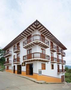 a large white building with balconies on it at Hotel Madre Laura Jericó in Jericó