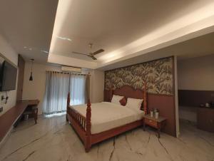 MajuliにあるHotel Srimanta sankardevの壁に絵が飾られたベッドのある寝室