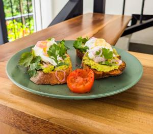 a green plate with three pieces of toast with eggs and a tomato at Arice Eco Villa and Restaurant in Galle