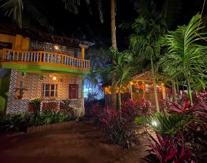 a house with a balcony and a garden at night at Areca Nest in Gokarna +25 photos