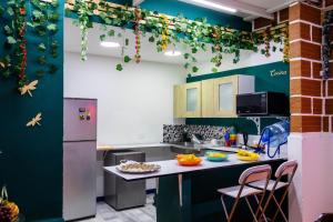 a kitchen with green walls and a table with food on it at S23 I City Lodge in Sabaneta
