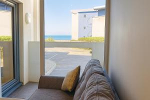 Habitación con sofá y vistas al océano. en West Beach - Holiday Apartments, en Westward Ho