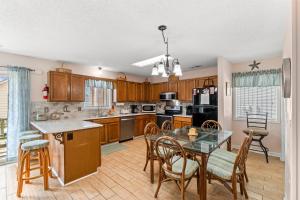 マートルビーチにあるPerrin Place C - 3rd Row - Ocean Drive Sectionの木製のキャビネットとテーブルと椅子を備えたキッチン