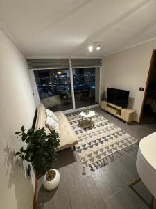 a living room with a couch and a tv at Frente a Playa Brava, Cerca Cavancha, WiFi in Iquique