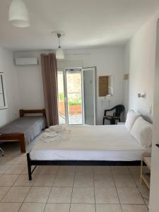 a hotel room with two beds and a balcony at Joanna Rooms in Skala Eresou +86 photos